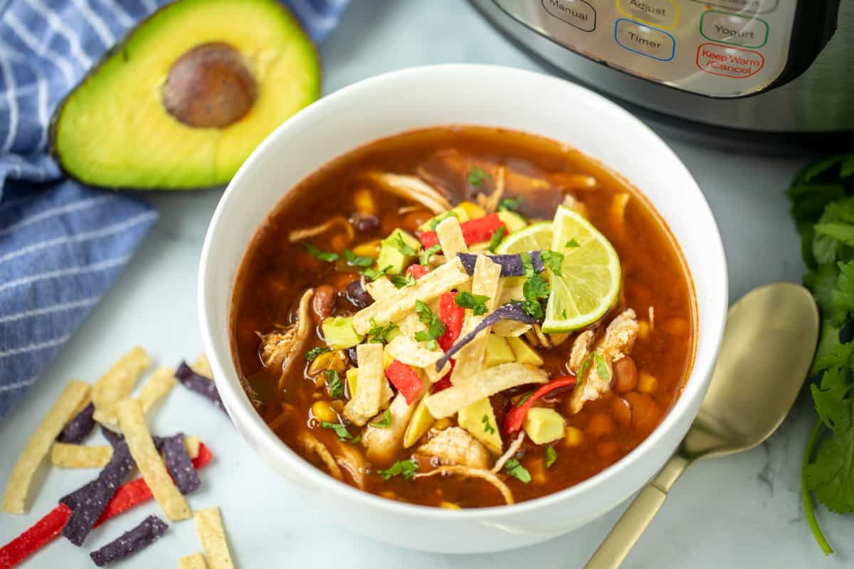 Bowl of chicken tortilla soup next to instant pot. 