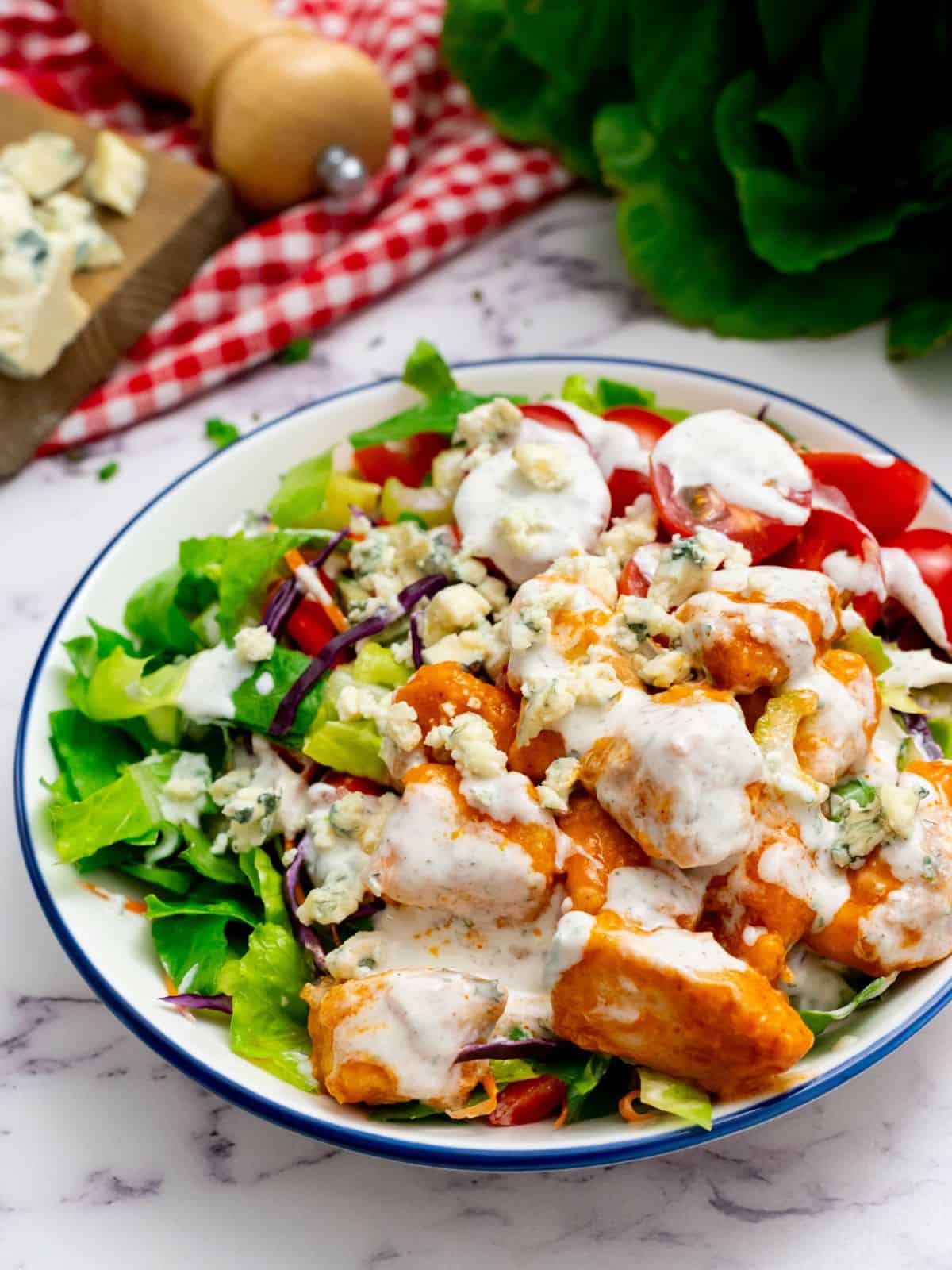 Bufflalo Chicken Salad with creamy ranch dressing plated in large bowl.