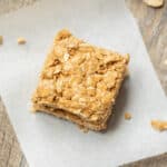 PB Oat Bar on parchment paper next to tray of snack bars.