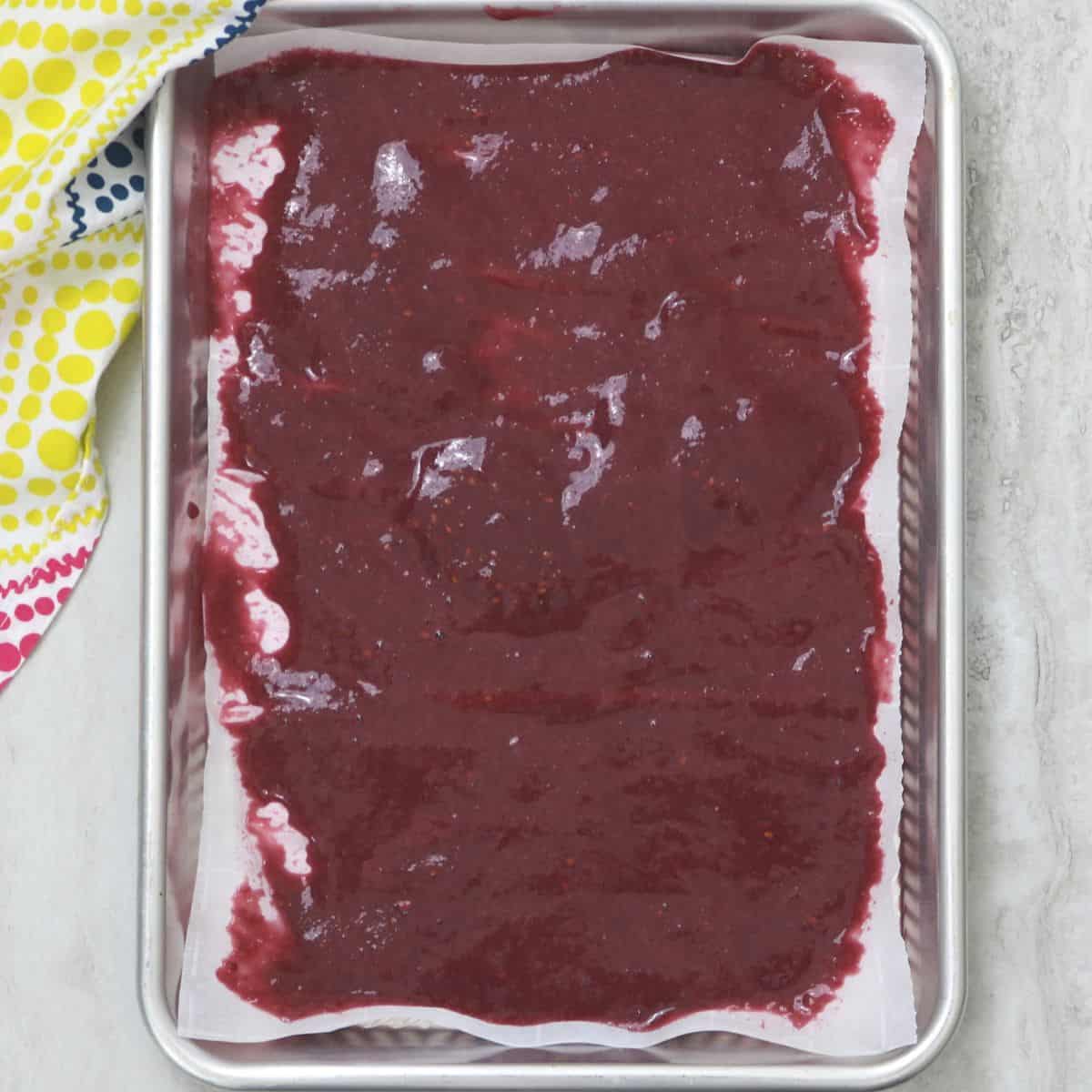 Fruit roll up mixture spread out on sheet pan.