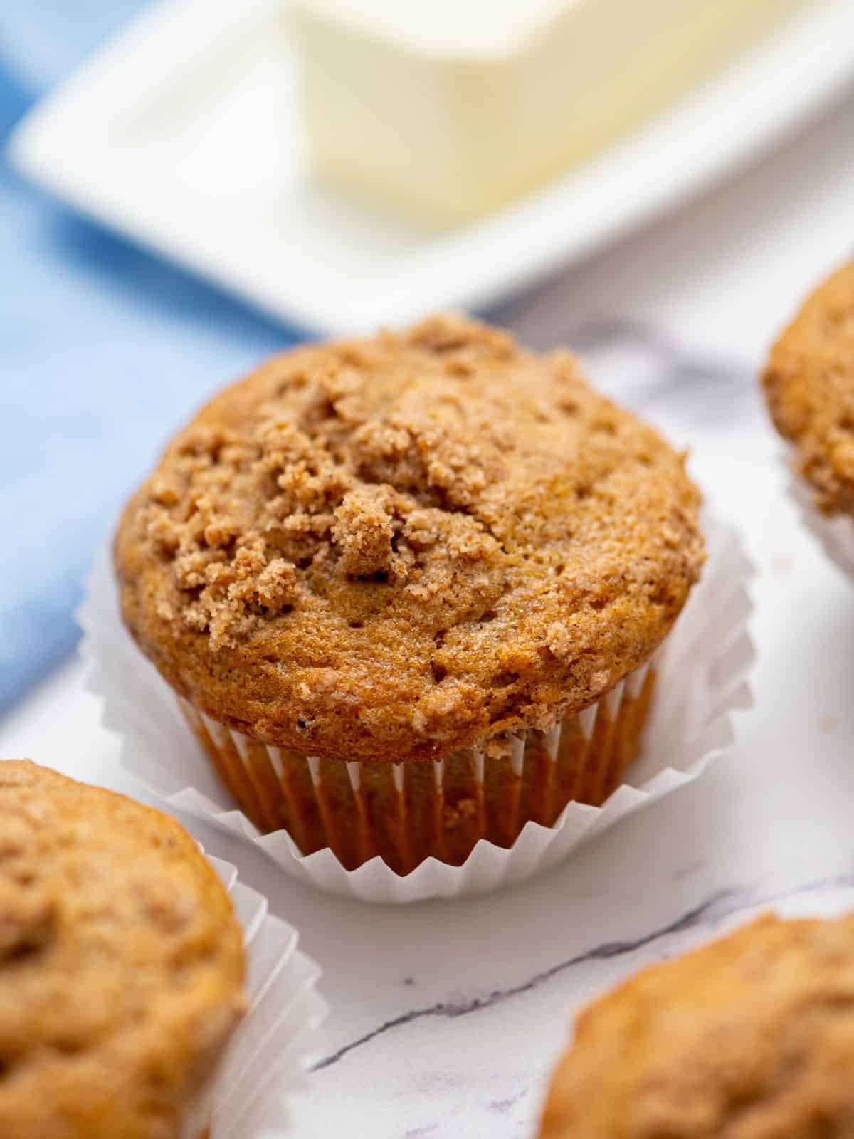 Baked gluten free muffins with streusel on white counter.