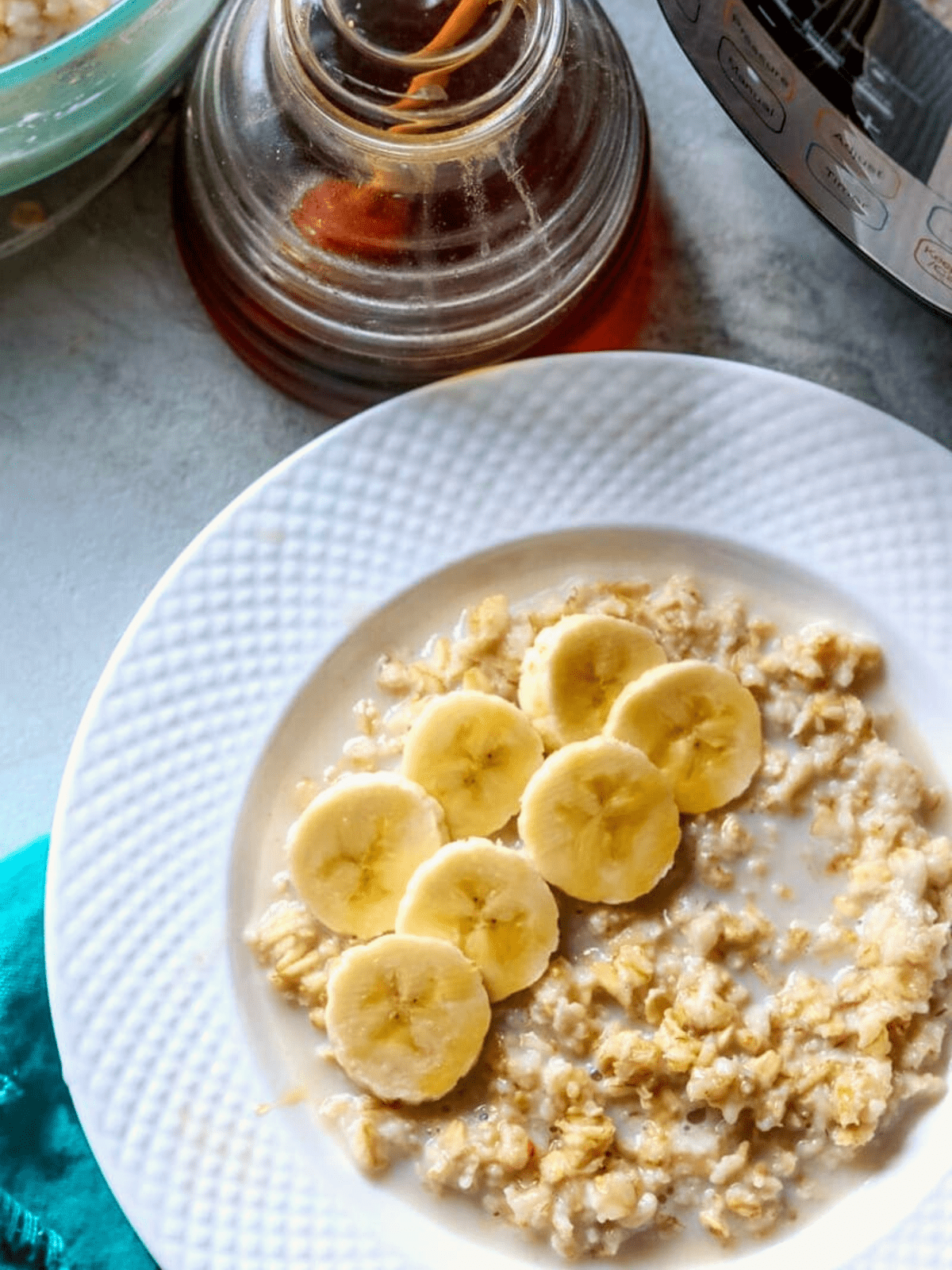 Bowl of instant pot oatmeal topped with sliced banana and honey.