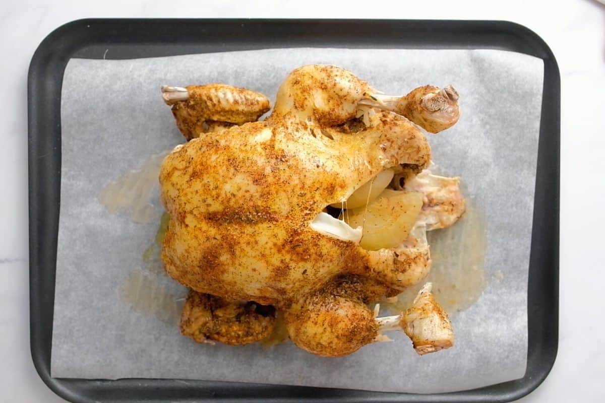 Whole Chicken on baking sheet after being broiled.