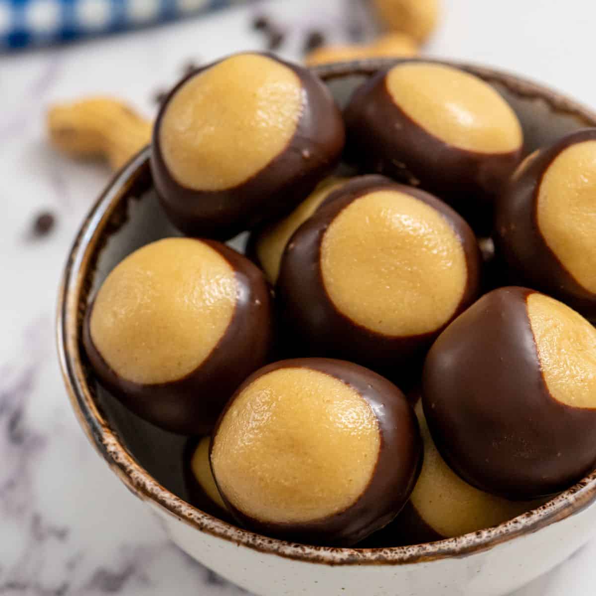 Close up of prepared peanut butter buckeyes in a bowl.