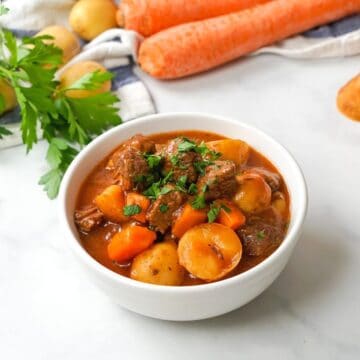 Bowl of instant pot beef stew topped with parsley.