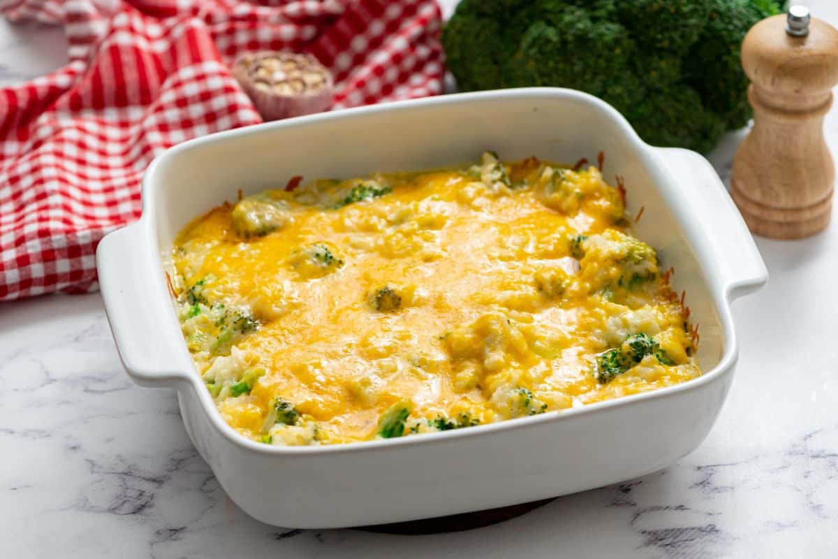 Baked Broccoli Rice Casserole topped with cheese in white casserole dish.