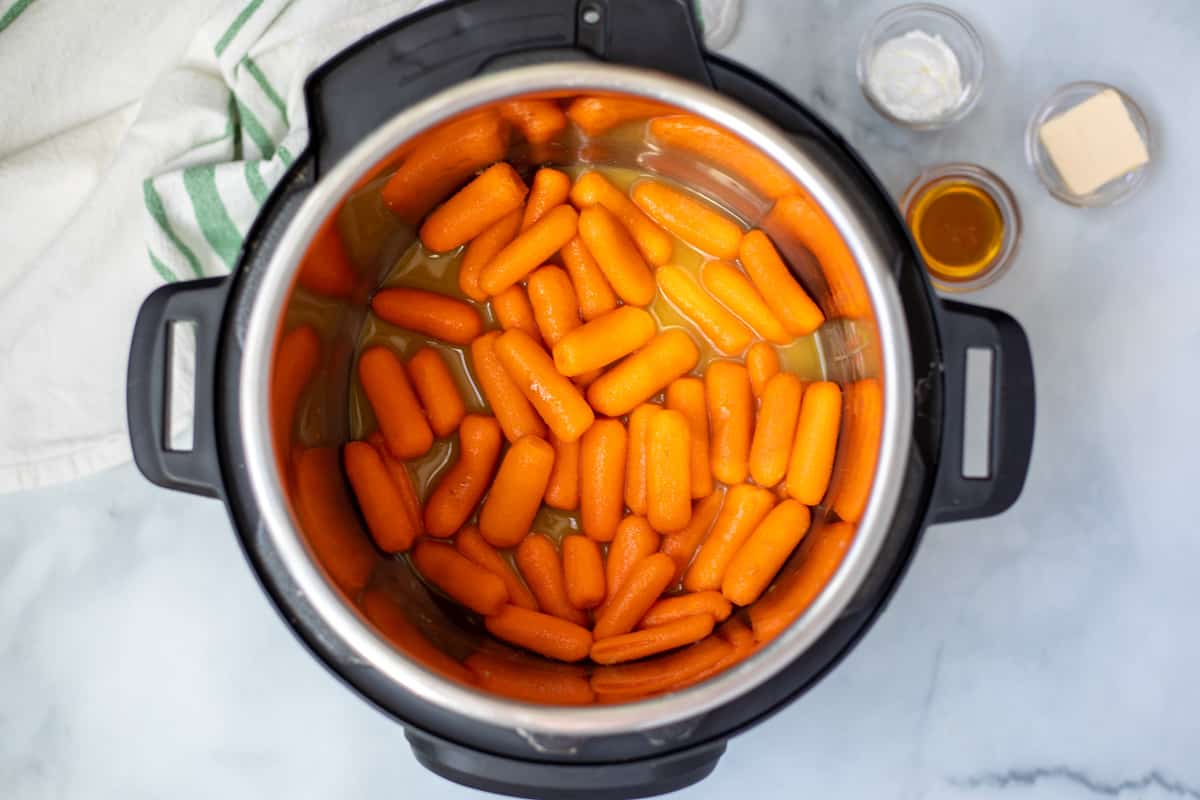 Raw carrots in inner pot with seasonings.