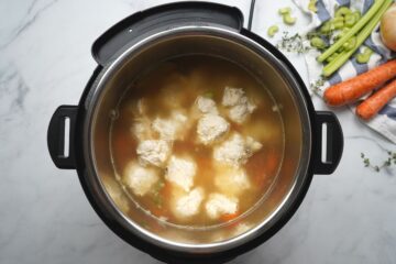 Chicken soup with dumplings in broth before pressure cooking.