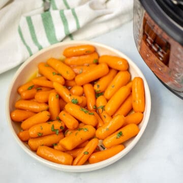 Bowl of instnat pot carrots topped with glaze and parsley.