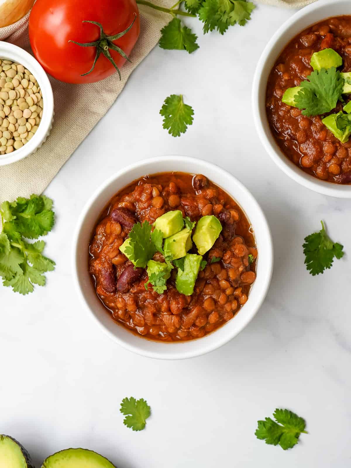 Bowl of homemade Instant Pot Lentil Chili topped with avocado and cilantro.