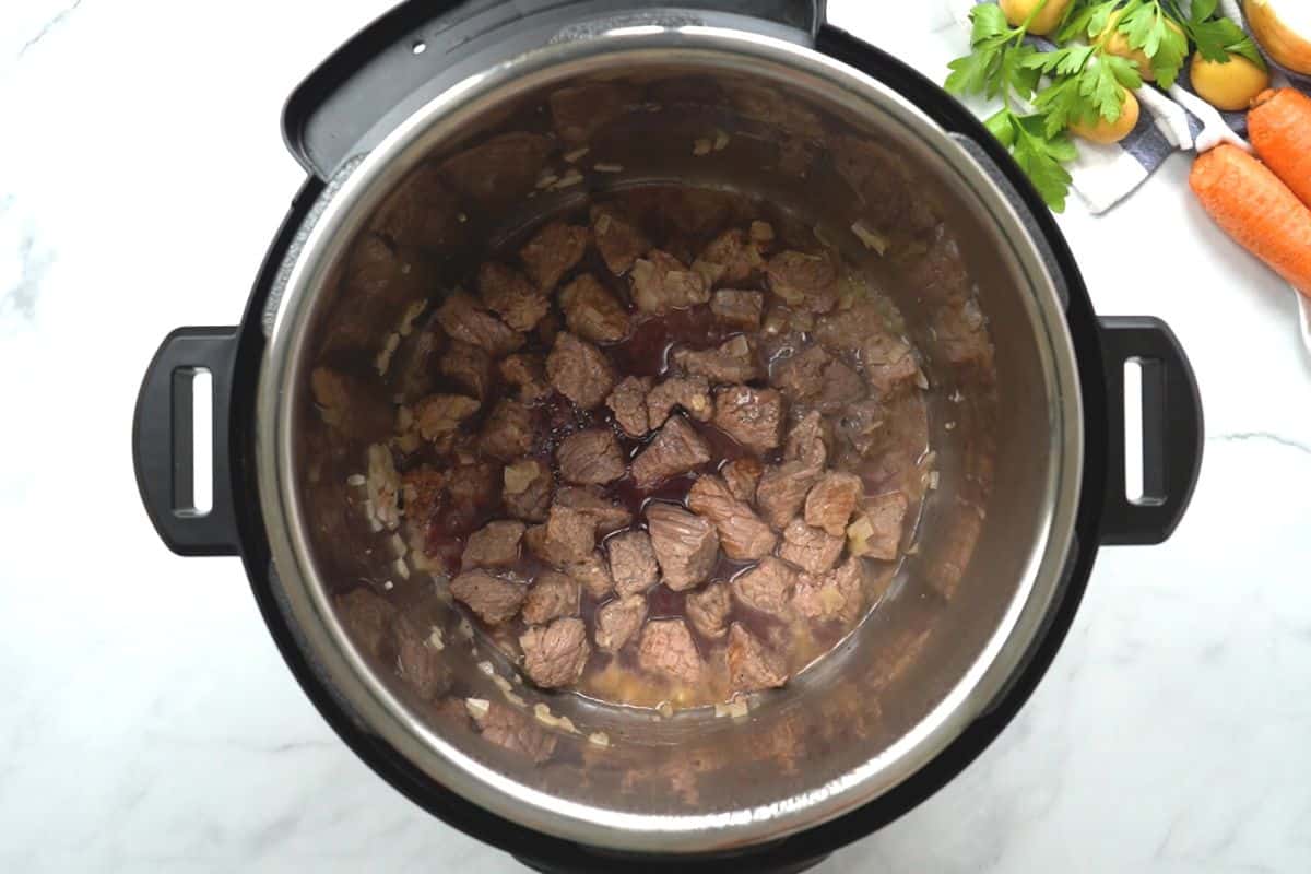 Seared beef and red wine inside inner pot. 