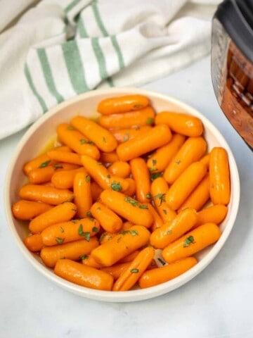 Bowl of instnat pot carrots topped with glaze and parsley.