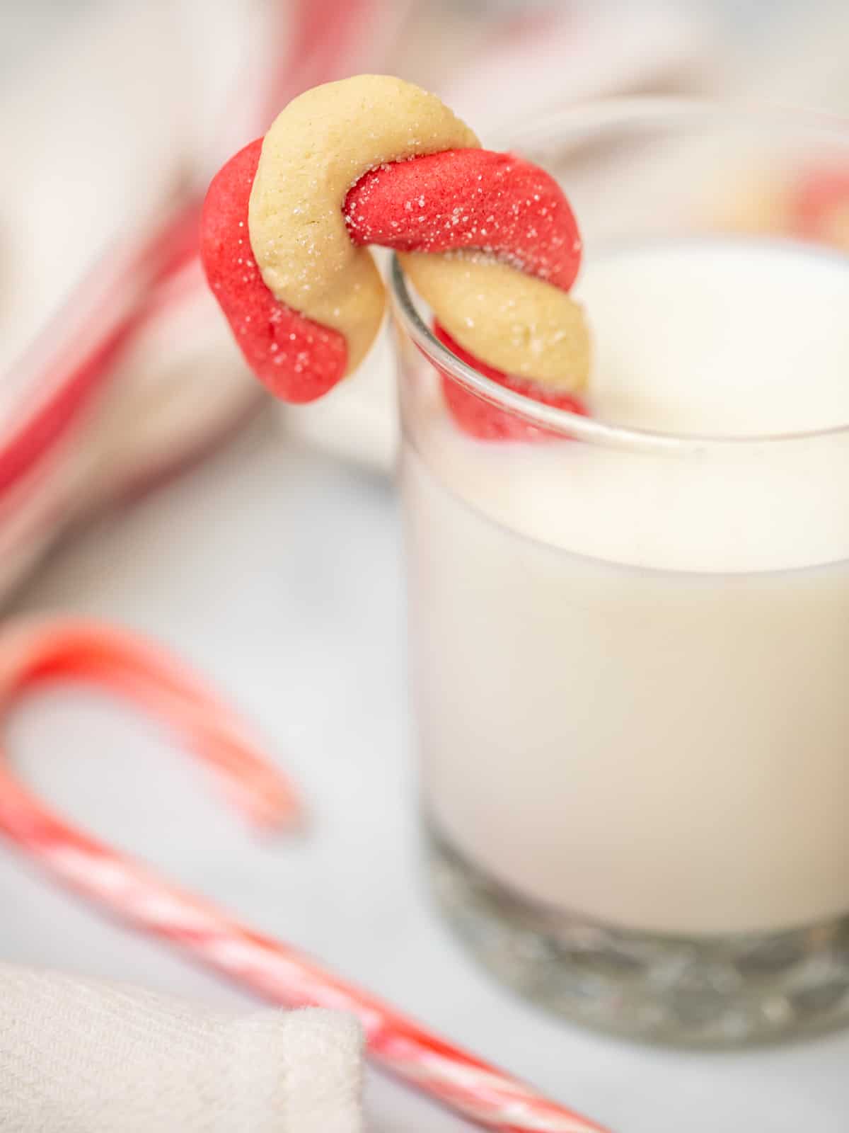 Candy Cane Cookie dipping into glass of milk.