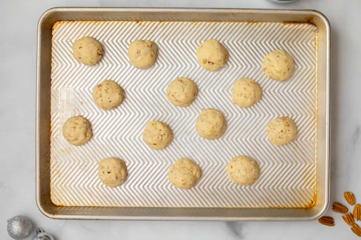 Baked snowball cookies on the baking sheet.
