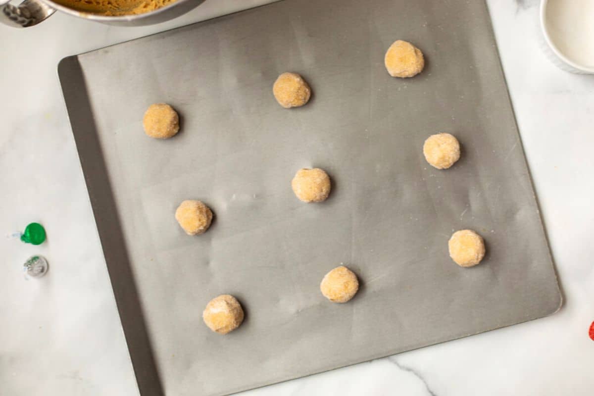 Peanut Butter Cookies on baking sheet after being rolled in sugar.