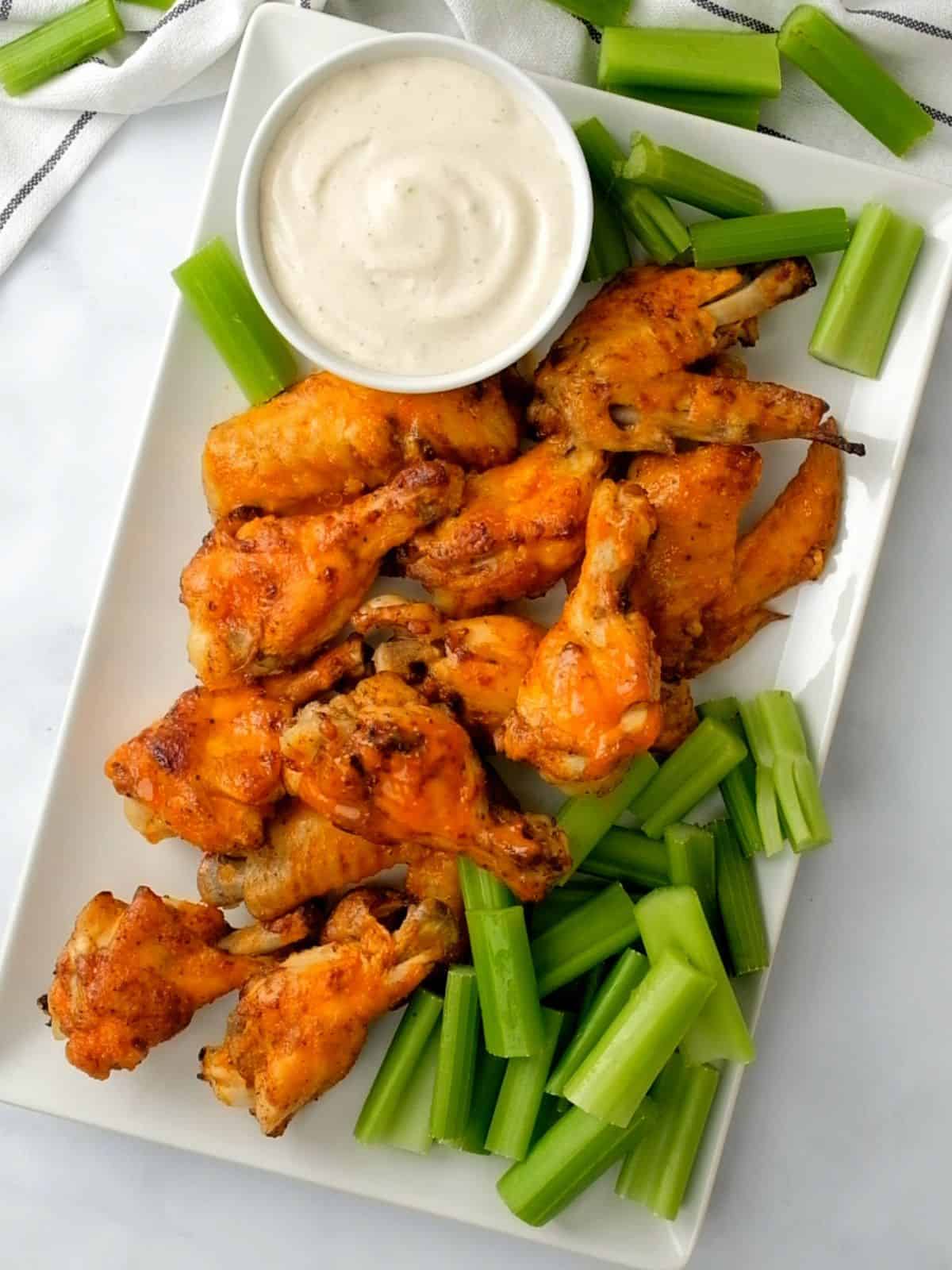 Instant Pot Chicken Wings on white platter with celery.
