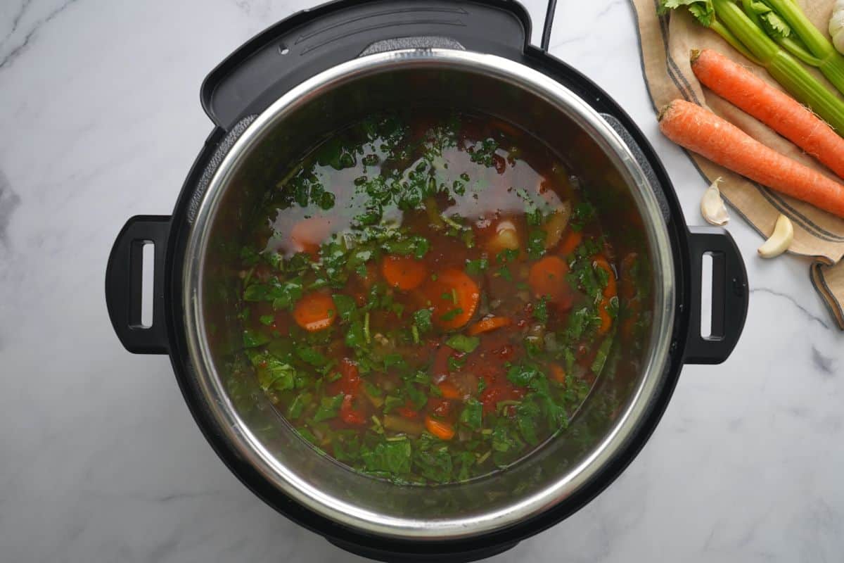 Vegetable soup after adding greens to inner pot.