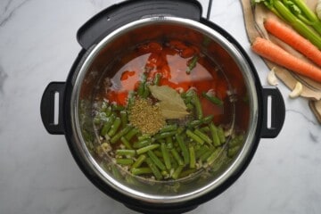 Ingredients for vegetable soup layered in inner pot.