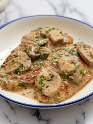 Prepared Chicken Marsala plated and topped with parsley.