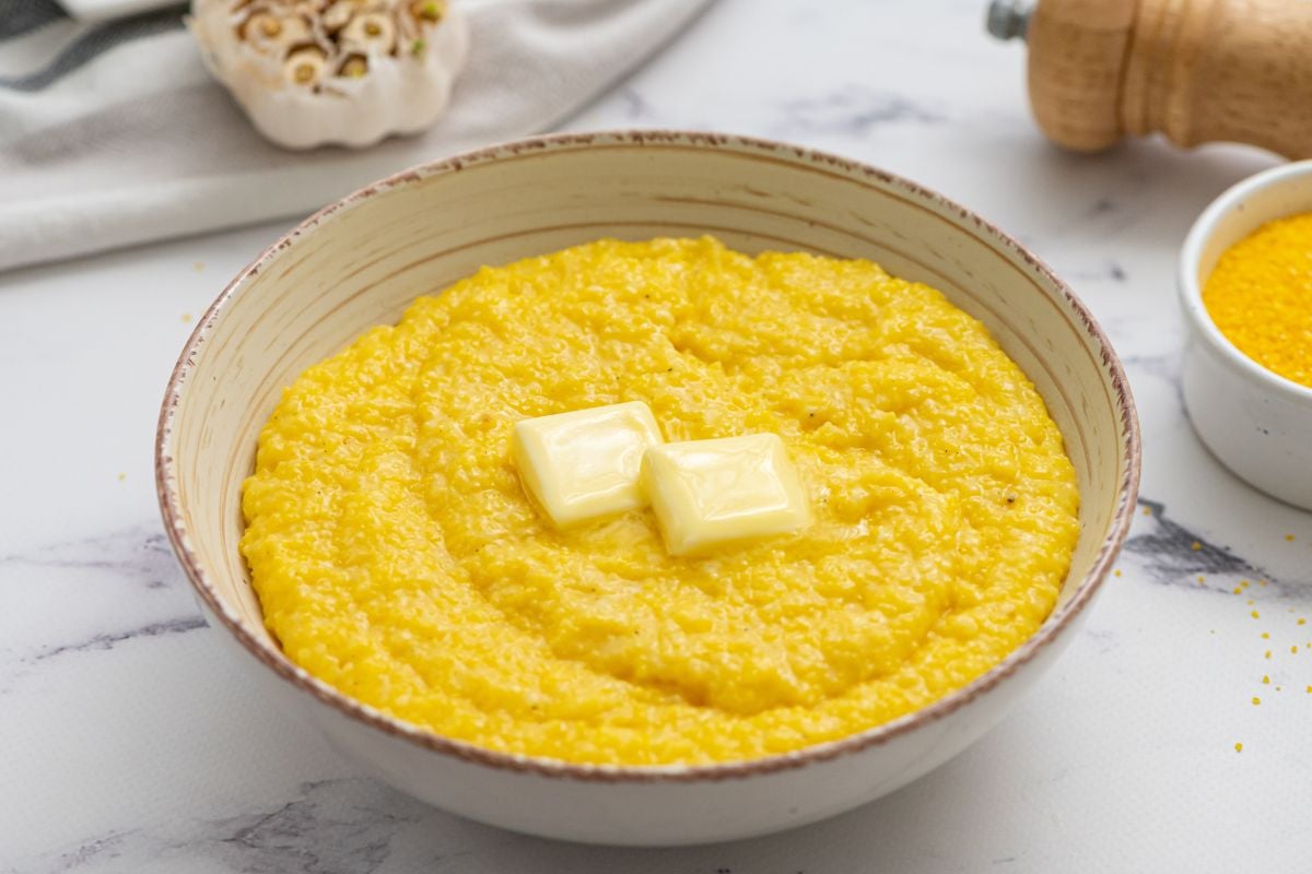 Bowl of cheese grits topped with butter.