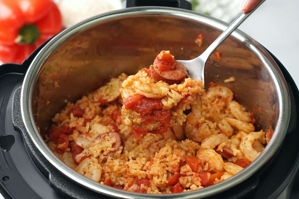 Spoonful scooping out jambalaya out of instant pot.