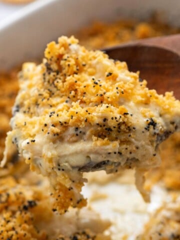 Spoonful of chicken poppy seed casserole coming out of casserole dish.