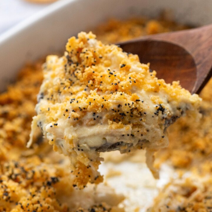 Spoonful of chicken poppy seed casserole coming out of casserole dish.