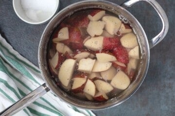 Saucepan with quartered red potatoes covered with water.