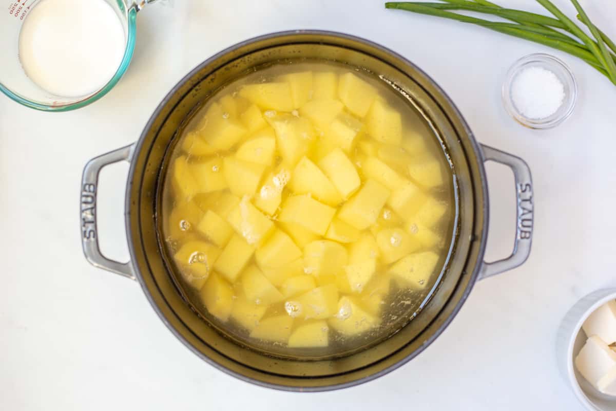 Cubed potatoes in dutch oven covered with water.