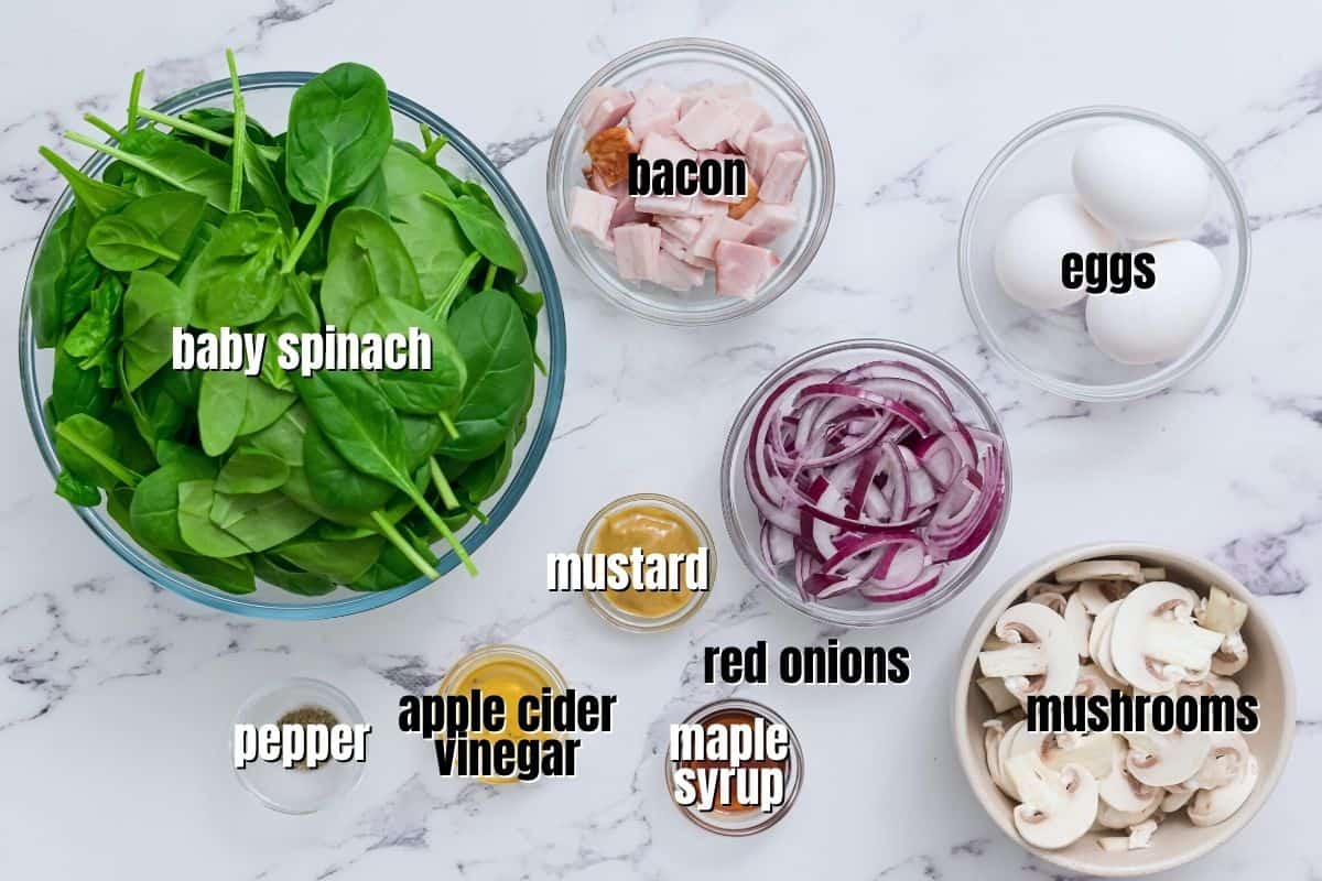 Ingredients for spinach salad labeled on counter.