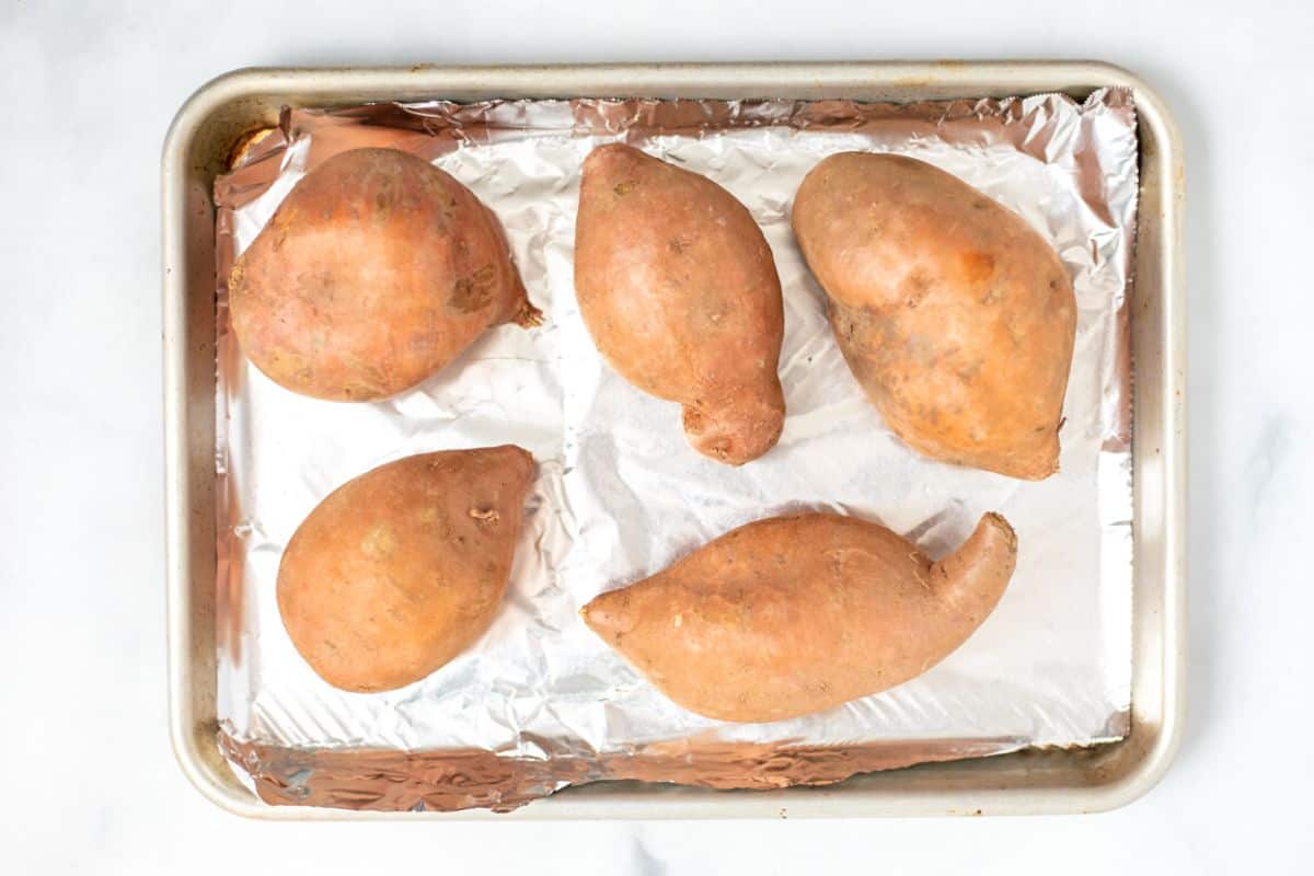 Sweet potatoes on foil lined baking sheet. 