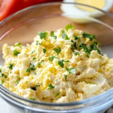 Bowl of egg salad topped with parsley.