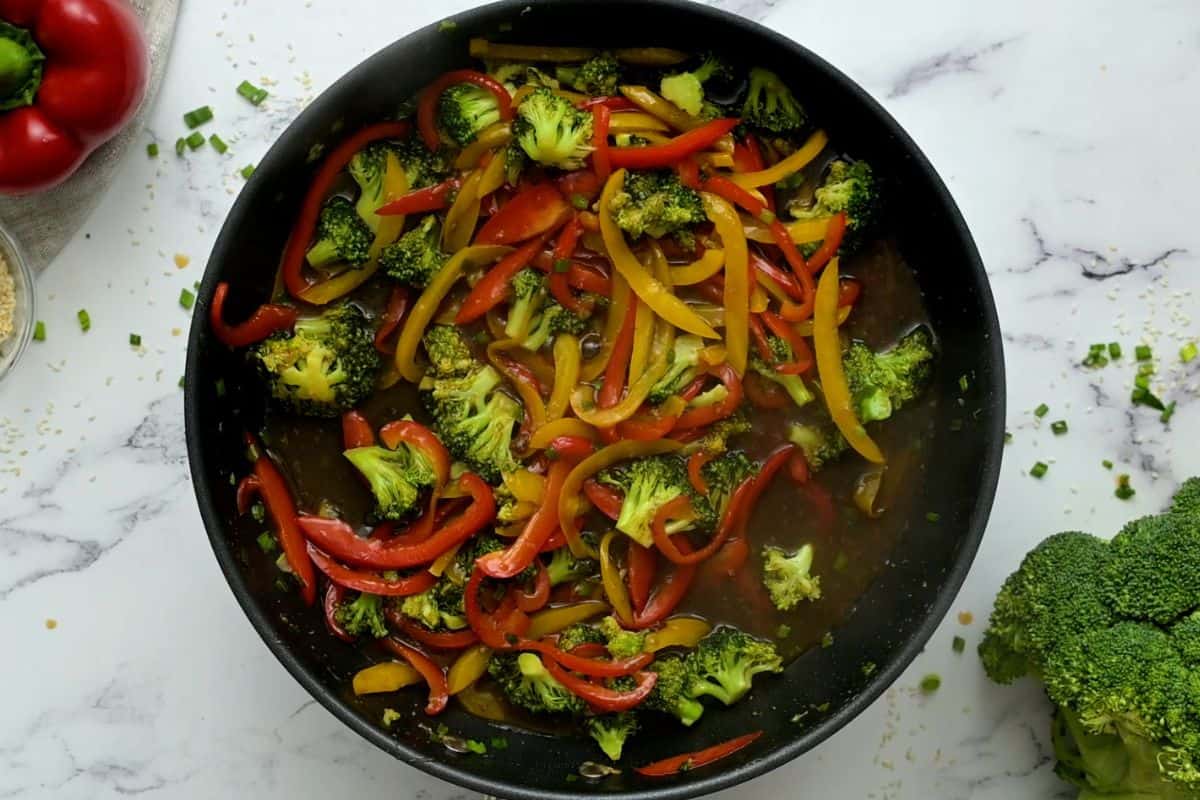 Vegetables and stir fry sauce in skillet.