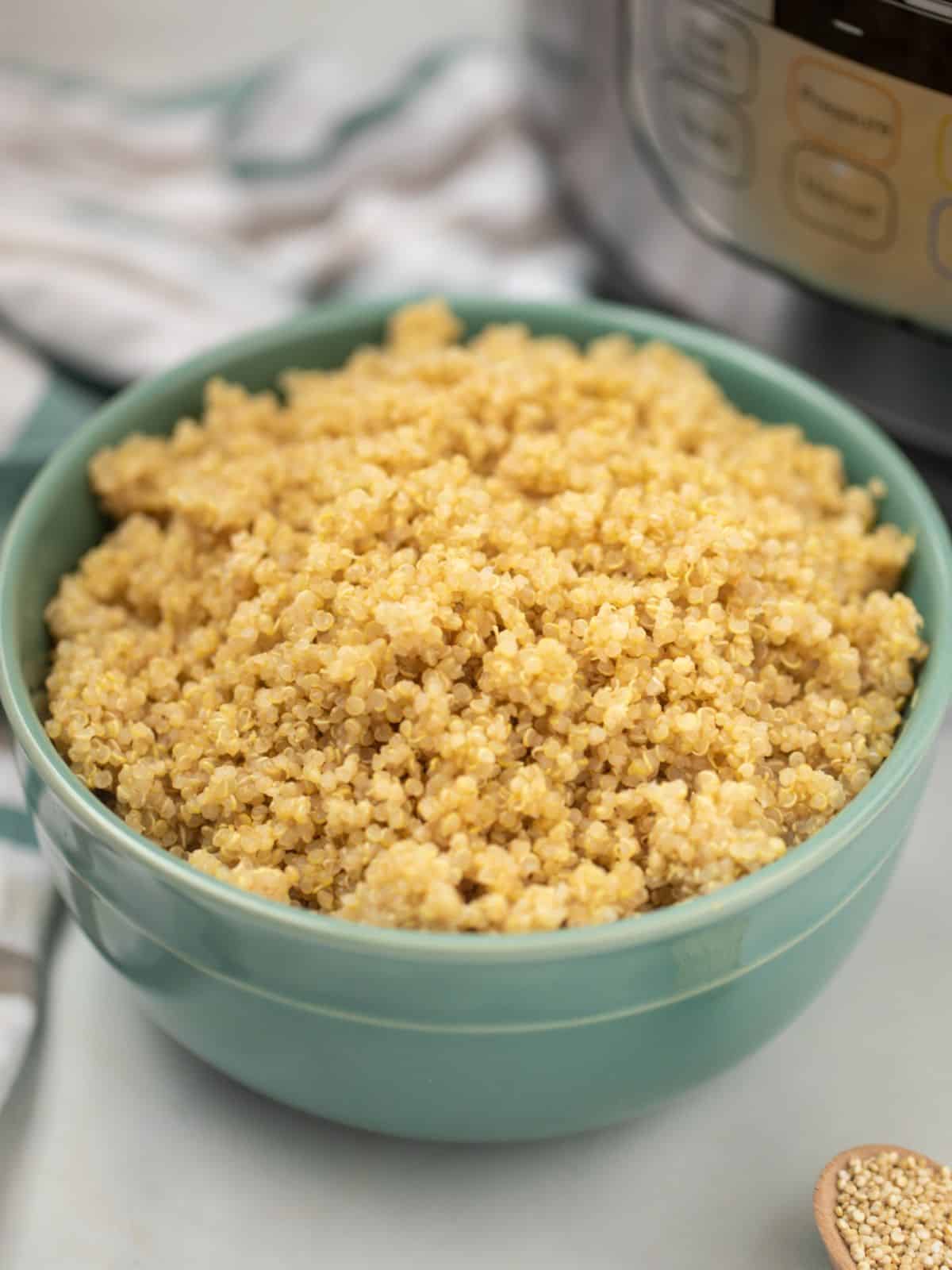 Cooked quinoa in a bowl in front of the Instant Pot.