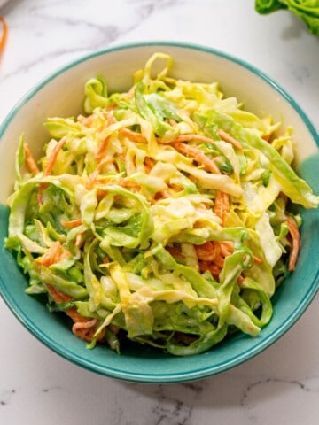 Bowl of creamy coleslaw made with shredded green cabbage.