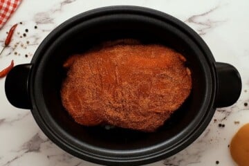 Seasoned pork butt in slow cooker.