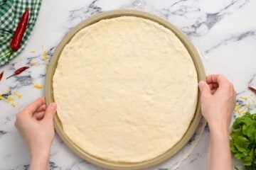 Pizza dough shaped to fit 12-inch pizza pan.