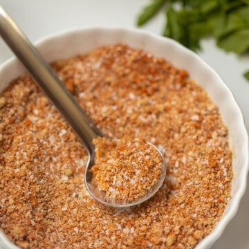 Close up of dry rub mixed together in small white bowl with spoon showing dry rub.