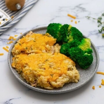 Chicken and Rice Casserole plated on gray plate next to steamed broccoli.