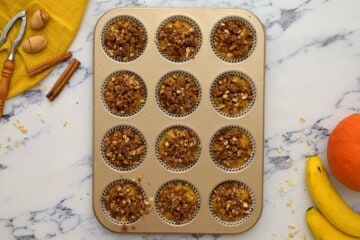 Pumpkin Banana Muffin Batter divided evenly between 12 muffin cups topped with streusel.