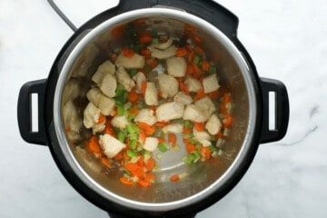 Chicken, carrots, onions, and celery sauteed in inner pot.