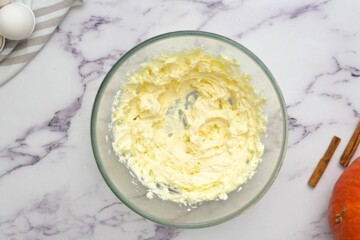 Cream cheese and butter creamed in clear mixing bowl.