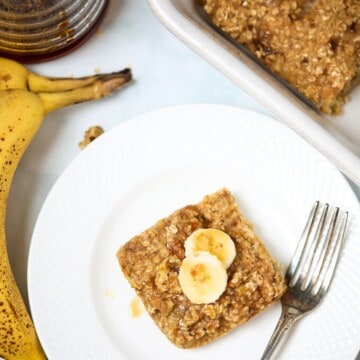 Slice of banana baked oatmeal on plate next to fork.