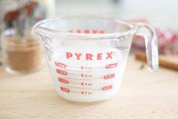 Milk frothed in pyrex glass mixing cup.