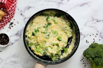 Broccoli, rice, cheese, and sauce mixed together in sauce pan.