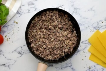 Ground beef, sausage, garlic, and dried herbs in saute pan.