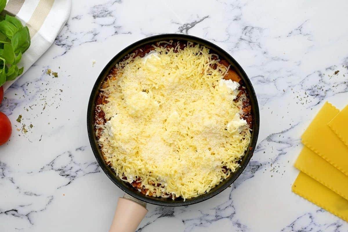 Skillet Lasagna topped with ricotta cheese and shredded mozzarella cheese. 