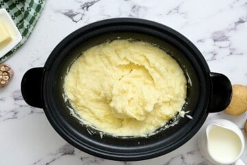 Mashed potatoes in crockpot after adding milk and sour cream.