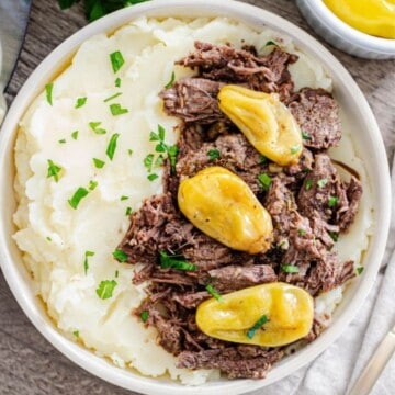 Instant Pot Mississippi Pot Roast dished up with mashed potatoes in serving bowl.