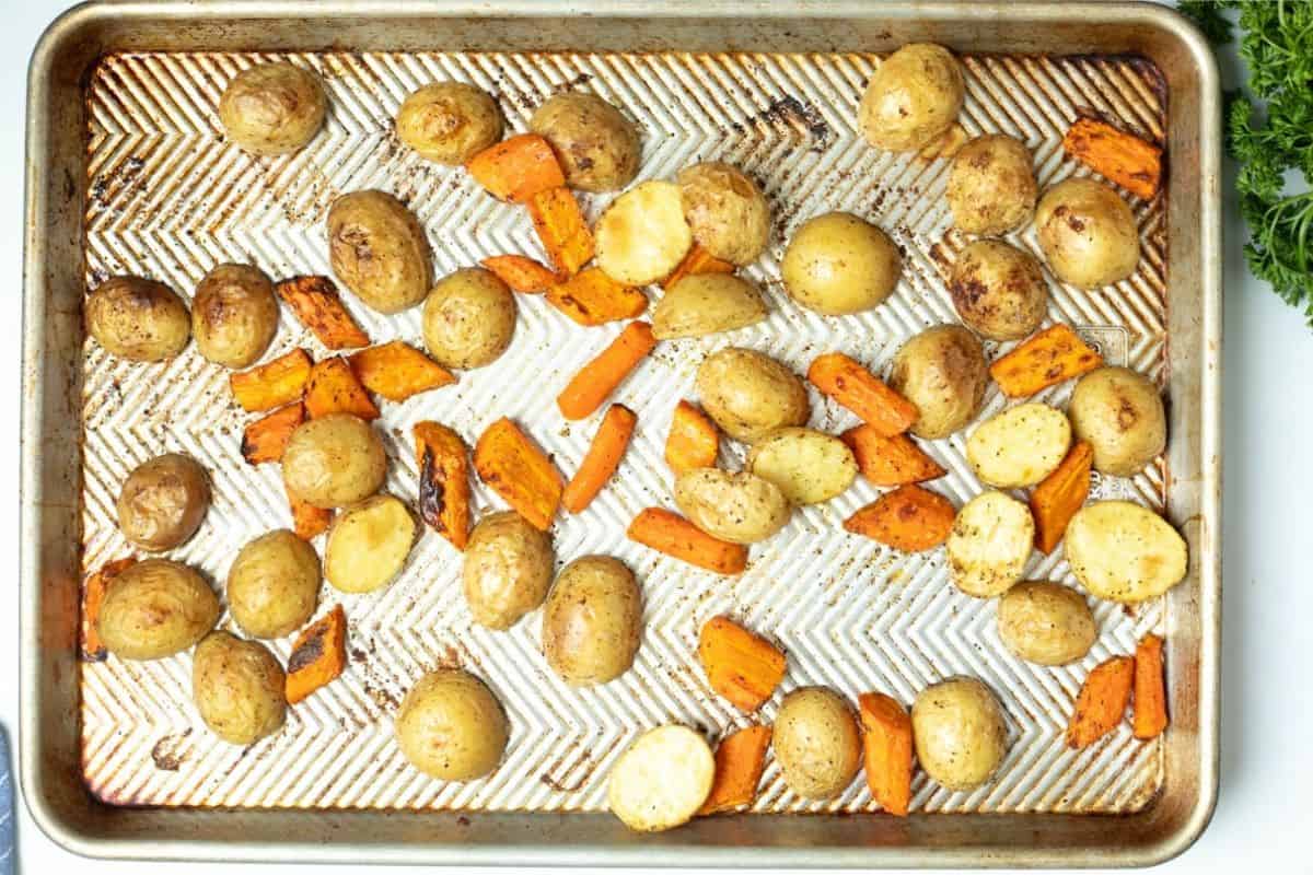 Roasted potatoes and carrots on sheet pan.